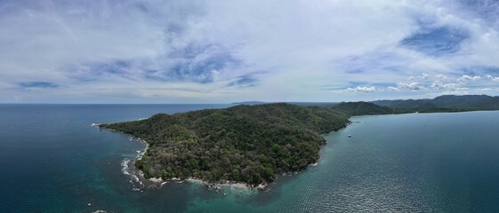 Experience the ultimate tropical getaway at Tambor Beach in beautiful Costa Rica, complete with swaying palm trees and white sand.