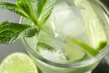 Glass of tasty mojito on table, closeup