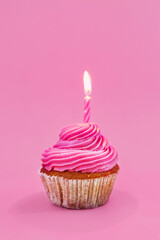 Tasty cupcake with birthday candle on pink background