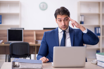 Young male employee and too much work in the office