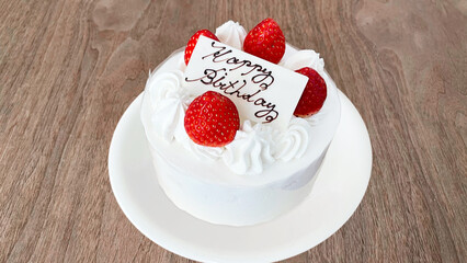 テーブルに置かれた誕生日用ホールケーキ