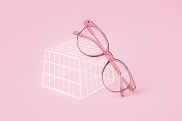 Stylish eyeglasses and plastic box on pale pink background