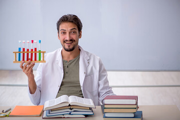 Young male chemist teacher in front of whiteboard