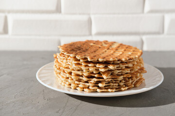 stack of thin round waffels on white plate. fresh baked homemade simple waffers. crispy dessert