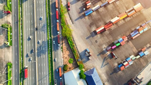 The yard is organized into different areas, including storage areas for loaded and empty containers, areas for container maintenance and repair, and areas for truck and rail loading and unloading.
