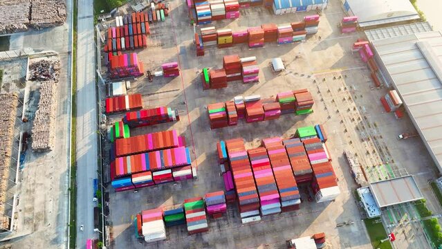 A containers are stacked in rows and columns, often several layers high, using specialized equipment such as container cranes, straddle carriers, or reach stackers. Transportation industry. 4K Drone
