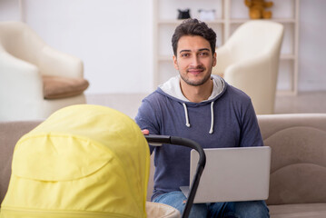 Young man looking after newborn at home