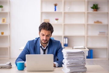 Young male employee and too much work in the office