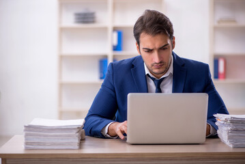 Fototapeta premium Young male employee and too much work in the office