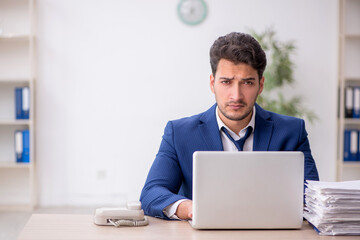 Young male employee and too much work in the office