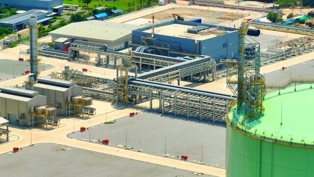 An LNG plant from a drone aerial perspective would appear as a large, complex industrial facility with various components involved in the processing and storage of liquefied natural gas. 4K HDR

