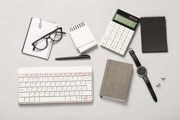 Composition with glasses, keyboard, notebook and calculator on white background