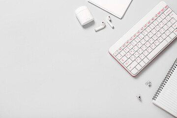Composition with keyboard, earphones and notebooks on white background