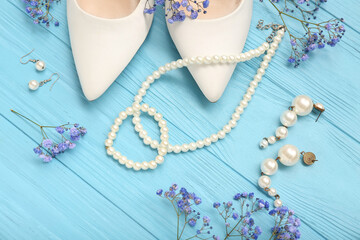 Composition with stylish female accessories, heels and gypsophila flowers on color wooden background