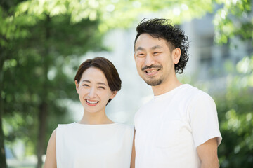Fototapeta premium 夏の日差しの中で笑顔で見上げるカップル 夏の旅行やお出かけのイメージ