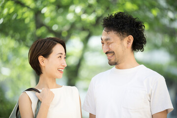 Fototapeta premium Couple smiling and gazing at each other in the summer sun Images of summer trips and outings
