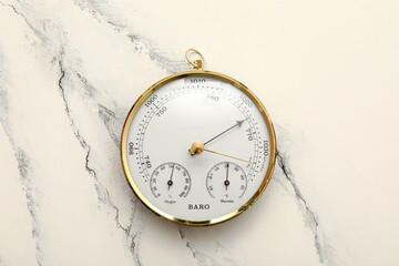 Aneroid barometer on white marble background