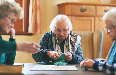 Senior women, board game and nursing home friendship or old people, thinking and play games...