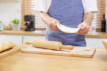 close up young man hands making a bread dough in the kitchen