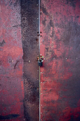 Ancient rusty iron door closed by a padlock