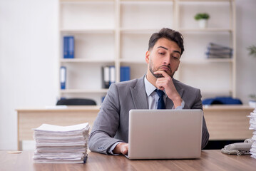 Young male employee and too much work in the office