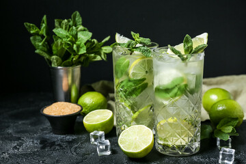 Glasses of cold mojito on dark background