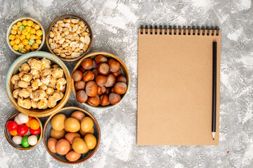 top view hazelnuts and peanuts with candies on a white background nut hazelnut walnut snack candy