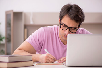 Young male student preparing for exams at home