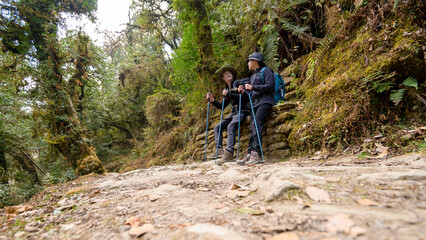 Obraz premium A young couple travellers trekking in Poon Hill view point in Ghorepani, Nepal.