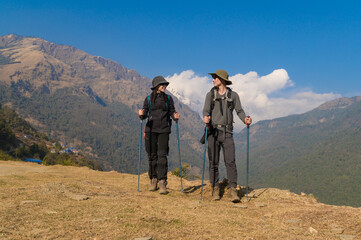 Obraz premium A young couple travellers trekking in Poon Hill view point in Ghorepani, Nepal.
