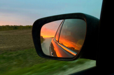 Reflection of the car in the mirror at sunset. Motorist's Day. World Car Free Day