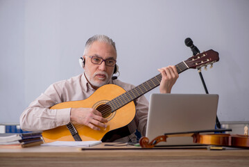 Obraz premium Old male music teacher in the classroom