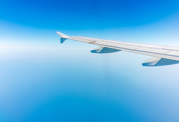 Obraz premium View from the airplane window at a beautiful cloudy sky and the airplane wing