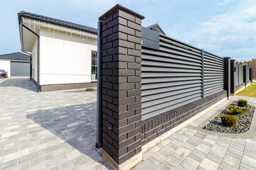 Fragment of a modern fence lined with decorative bricks in the old style