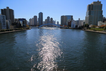 逆光に輝く隅田川の水面と高層ビル群