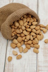 Nuts of bitter almonds, in a heap, on the table, in a bag, in a pile, on a white table, bitter almonds, unpeeled, in the shell, background, day, background image, wallpaper