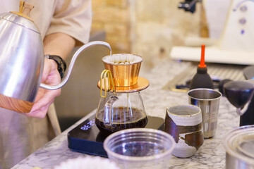 barista preparing coffee with drip coffee and drop the water on coffee ground with filter