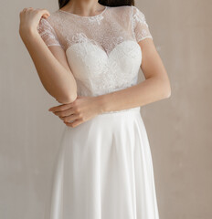 Beautiful bride in the white wedding dress decorated with floral lace. Gorgeous short sleeves wedding dress decorated with lace