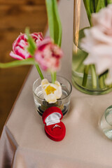 Engagement, ring in a red box. Location for surprise marriage proposal. Decoration with tulips flowers. Table setting for couple on Valentine's day in the restaurant. Luxury romantic date. Top view.