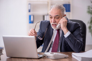 Fototapeta premium Old male employee and too much work in the office
