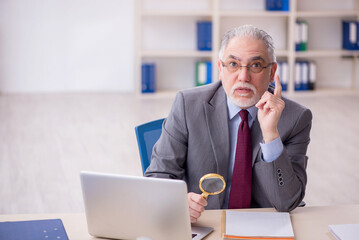 Old male employee working in the office