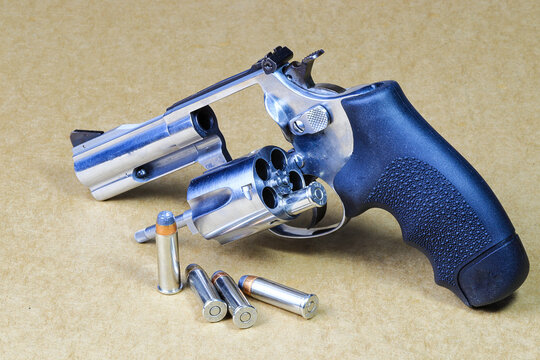 The compact revolver gun, stainless steel j-frame m60 pistol front left side view, with open cylinder prepare for use isolated on white background.