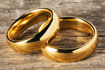 Golden wedding rings on wood