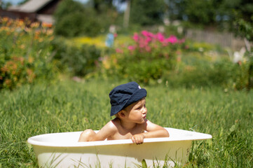 Happy child in panama outdoors in green field during summer holidays