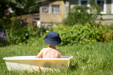 Happy child in panama outdoors in green field during summer holidays