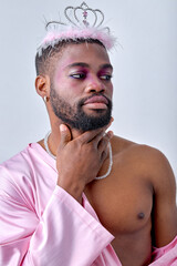 Adorable black american gay man with make up in stylish clothes looking at side, touching himself, half-naked, in crown, isolated on white background studio portrait People lgbt lifestyle concept