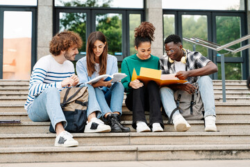 Young students sitting on University stairs. College friends studying together after class 
