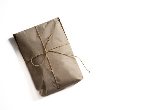 ecological gift wrapping in kraft paper and cotton string on a white background copy space 