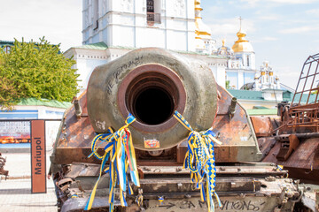 The barrel of a burnt russian tank with Ukrainian yellow and blue ribbons.