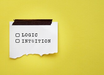 On yellow background, torn note with check boxes and text LOGIC and INTUITION, concept of choosing logic to make decision or follow instinct trusting intuition which valuable in some circumstance